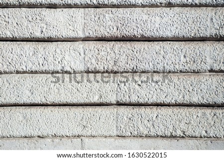 Bright white plaster stucco base facade wall background texture with horizontal lined big parallel brick blocks