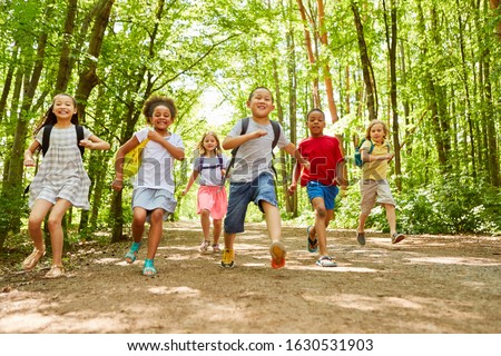 Group of children with backpack makes a race in nature in summer