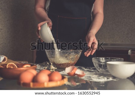 girl preparing cookies in the shape of a heart for the holiday Valentine's Day at home, in a small bakery, family business, authentic, hobby, mood, cozy. Care and love
