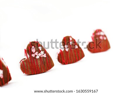 Decorated heart shaped cookies in the box on white background.