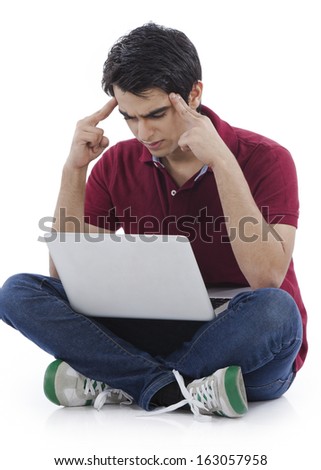 Man suffering from a headache and looking at a laptop