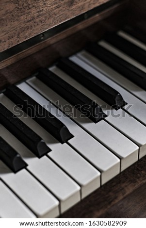 A vertical closeup of a piano under the lights - a nice picture for wallpapers and backgrounds