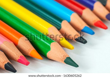 Close up picture of many  colored pencil crayons on white background. Assortment of sharpened colored pencils/ Colored drawing pencils. Selective focus. 