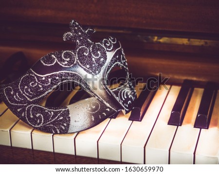 Vintage carnival mask on the background of piano keys. Top view, closeup