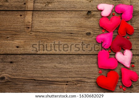 Valentines Day or Wedding background. Romantic and love emotion. Multicolored felt hearts on vintage wooden boards background, copy space, top view