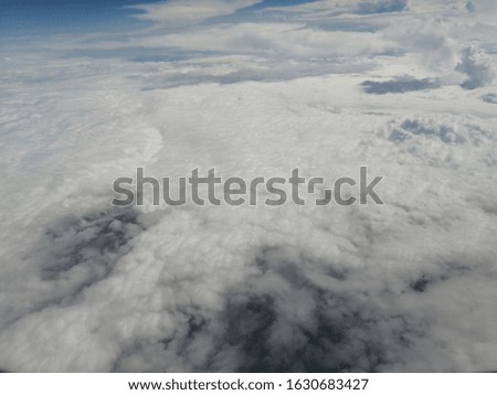 Looking from the plane window to see the clouds.