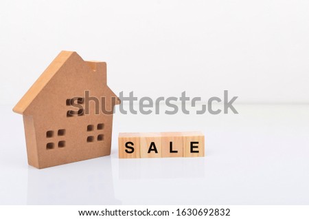 Model house with inscription SALE letters word on wooden cubes. Real estate mortgage property insurance sweet home ecology. Rent concept.