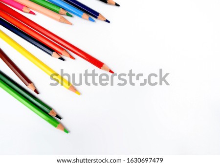 bunch of wax crayons of different colors are scattered randomly on a bright white background