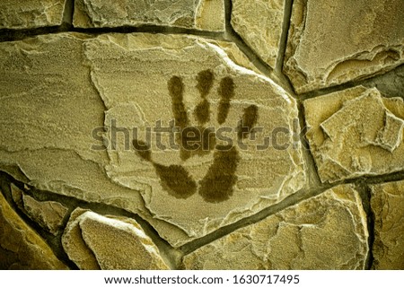 a blurred handprint on a frozen brick wall, palm prints in winter