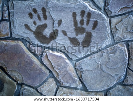 a blurred handprint on a frozen brick wall, palm prints in winter