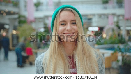 Portrait face young beautiful woman wear green hat look at camera smile happy fashion Christmas holidays attractive winter model person casual close up slow motion