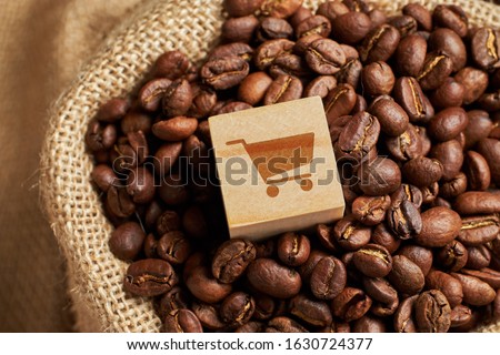 Abstract trolley sign on a wooden cube as a symbol of buying coffee beans in a knitted bag. Close up. Royalty-Free Stock Photo #1630724377