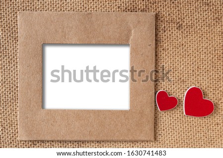 Blank vintage photo with miniature hearts on old cardboard surface