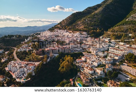 Aerial photo distant view charming Mijas pueblo, typical Andalusian white-washed mountain village, houses rooftops, small town located on hillside Province of Málaga, Costa del Sol, Europe, Spain