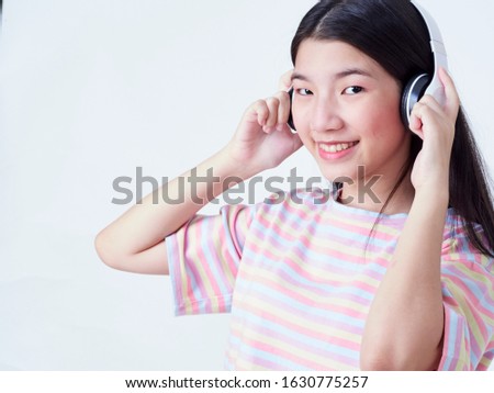 Teen girl with headphones listening to music isolated on white background. Studio shot.