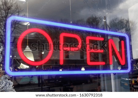 Neon sign OPEN with red letters on glass window