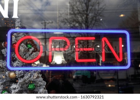 Neon sign OPEN with red letters on glass window