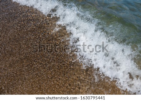 Waves and black sand of volcanic origin. Baia Domizia Coast, Province of Caserta, Italy
