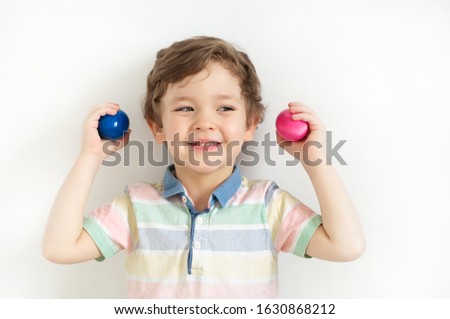 Happy Easter. Portrait of a pretty boy holding easter eggs standing isolated over white background. Emotions. Easter concept