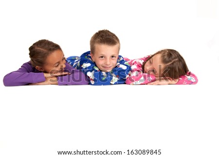 Three children laying down in winter pajamas