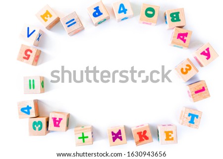 Kids toys wooden cubs with letters and numbers on white background. Frame from developing wooden blocks. Natural, eco-friendly toys for children. Top view. Flat lay. Copy space.
