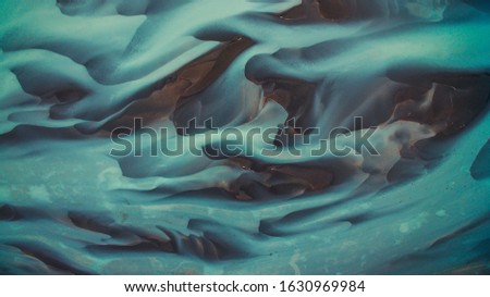 Bird's eye view from above on a green and blue glacier river stream in South Iceland. Beautiful patterns, textures and structures. Melting glacier, Global warming and climate change concept Royalty-Free Stock Photo #1630969984