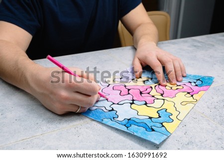 man draws an abstract imaginary picture with a pencil and decorates it with different colors, a psychological test for the subconscious