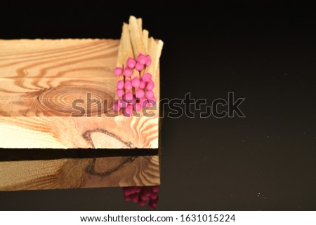 Several wooden matches lie on a wooden board on a black background.