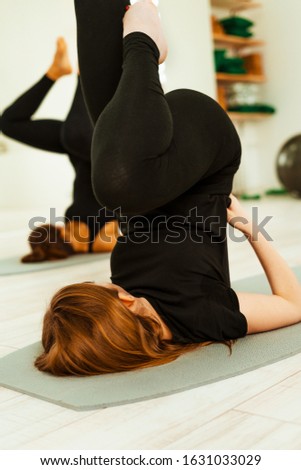 Stretching workout. A group of young girls in black uniforms are doing stretching training in the gym. Akroyoga, yoga, fitness, workout
