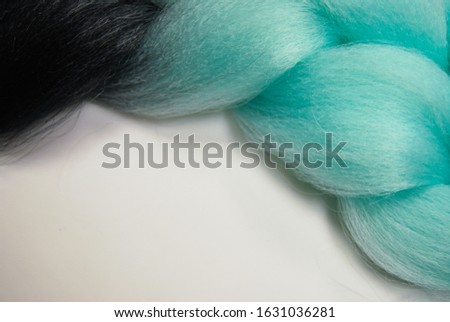 Kanekalon. Colored artificial hair strands. Synthetic hair materials for weaving African braids zizi. Close-up of bright colored hair. Overhead locks. Background for business cards.