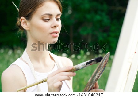 young woman with a brush in her hand an easel
