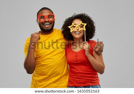 fun, photo booth and people concept - happy african american couple with party props hugging over grey background Royalty-Free Stock Photo #1631052163