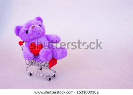 Valentines Day gift. Lilac Teddy Bear, bright plush toy with red heart in supermarket trolley.  Retro romantic style. Unusual creative greeting card. Family, wedding and friendship