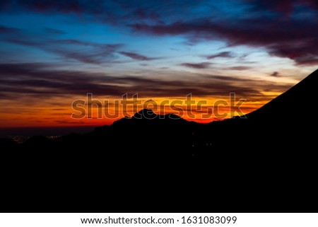 silhouettes of mountains backlit at dusk