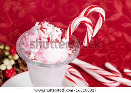 Peppermint ice cream with candy canes on red holiday background
