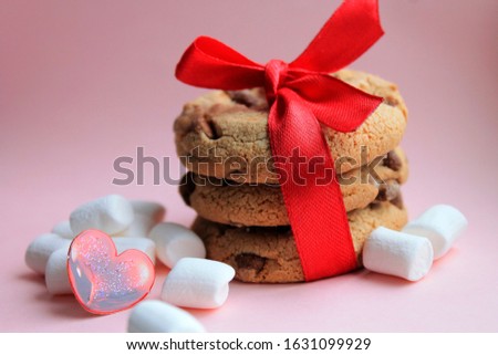 Valentine's day is March 8.Cookies with red ribbon and marshmallow on a pink background romantic style delicate tones. Family, wedding, and friendship.