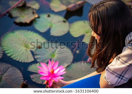 Happy woman sitting on the boat in the middle sea of red lotus, blossom red lotus in morning, (HappyConcept), (Natural Concept)