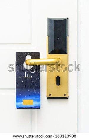 closed white door with a Do Not Disturb sign on the handle