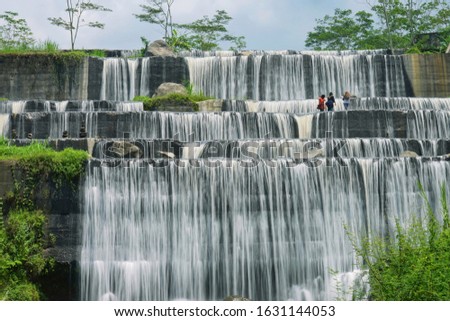 Three of moslem woman enjoying the  scenery of river water dam which have a beautiful six level waterfall  