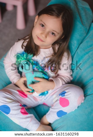 portrait of a little girl 5 years old with a toy dog ​​in his room. Happy child