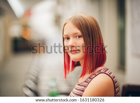 Outdoor close up portrait of pretty teenage girl with red dyed hair