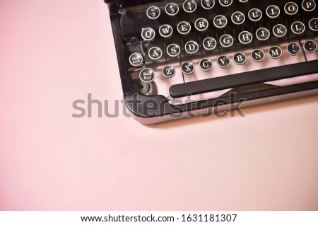 Vintage Black Typewriter Keyboard on Solid Pink Background