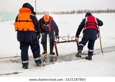 Slingers start a metal frame under the ice blocks in the lane