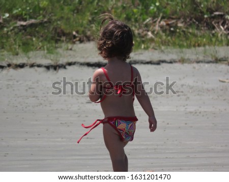 Child girl in beach outfit walking on sand