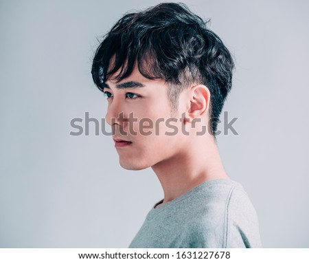 side view of young smiling handsome man isolated on gray background Royalty-Free Stock Photo #1631227678