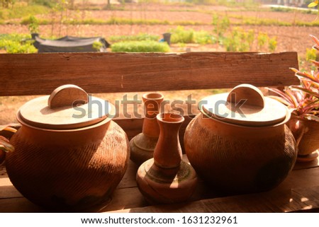 this pic show local thai pots and jars earthenware with garden background