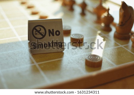 No smoking sign  On the checkers board  And the light from the window