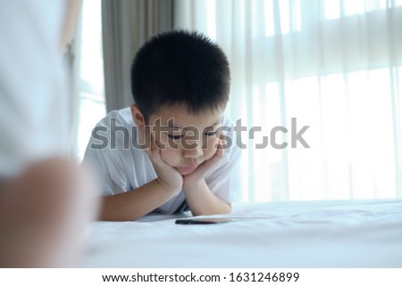 kid playing smartphone on bed, child addicted game and cartoon