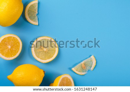 Lemon and slices on blue background. Selective focus. Copy space concept
