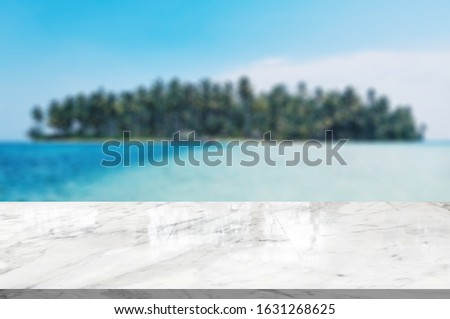 Marble table top on blurred blue sea of the background